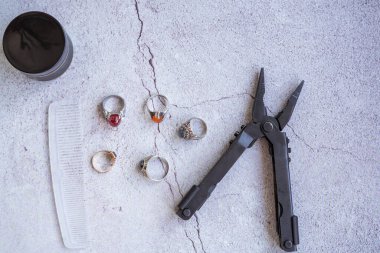 Şık erkek yüzükleri, kalem, aletler, mendil, poz ve tımar için parfüm. Beton arka planda metroseksüel sezaryenler. Şehir kompozisyonu. Üst görünüm.