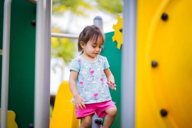 Çocuk parkında oynayan iki yaşındaki Asyalı kız ya da çocuk. Sağlıklı yaşam tarzları konsepti.