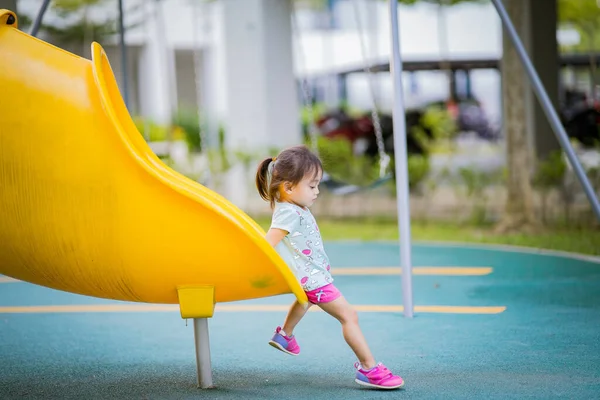 Çocuk parkında oynayan iki yaşındaki Asyalı kız ya da çocuk. Sağlıklı yaşam tarzları konsepti.