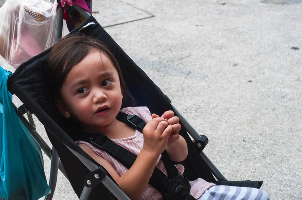 Bebek arabasında oturan Asyalı bir çocuğun portresi..