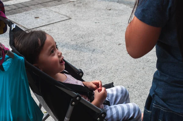 Bebek arabasında oturan Asyalı bir çocuğun portresi..