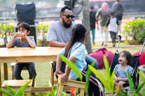 PUTRAJAYA, MALAYSIA - 6 Eylül 2019: Malezya 'nın Putrajaya kentindeki Royal Floria Putrajaya bahçesinde boş vakitlerinde oturan yerel aile.