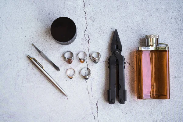 Şık erkek yüzükleri, kalem, aletler, mendil, poz ve tımar için parfüm. Beton arka planda metroseksüel sezaryenler. Şehir kompozisyonu. Üst görünüm.
