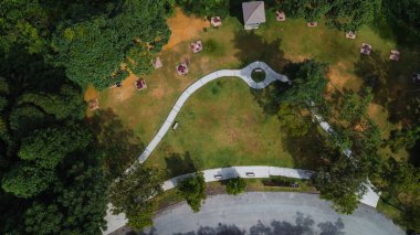 Gökyüzü fotoğrafı güneşli bir günde yeşil bölge ağaçları ve yürüyüş yolu olan bir şehir parkının uçan insansız hava aracından..