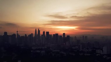 KLCC şehir silueti ile turuncu gün batımları gök gürültülü