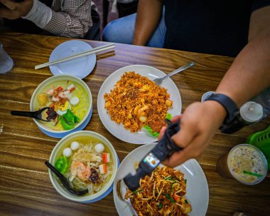Masadaki Çin Hokkien yemeklerinin en üst görüntüsü. Kamera da video çekiyor..