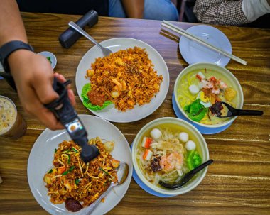 Masadaki Çin Hokkien yemeklerinin en üst görüntüsü. Kamera da video çekiyor..