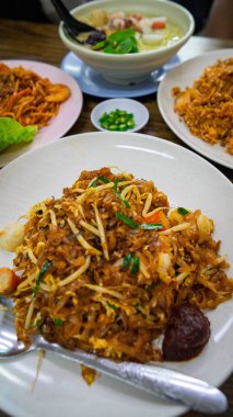 Çin Hokkien kue teow ve masada başka yiyecekler.