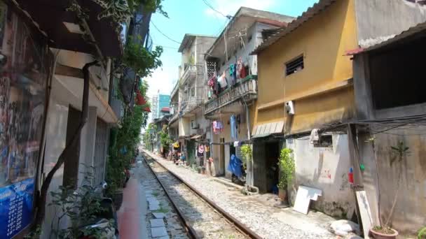 Železnice projíždějí živou čtvrtí. Typický pohled na Vietnam, Hanoj. — Stock video