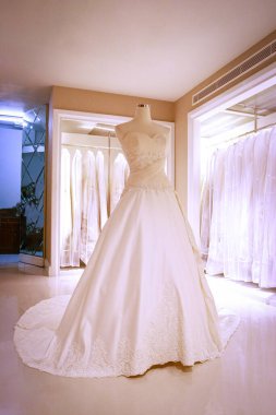 Şık bir gelin butiğinin mankeni üzerinde göz kamaştırıcı bir gelinlik Lüks Butik Showroom 'da Uzun Tren, Lace ve Fildişi Beyaz ile gösterimde Zarif Gelinlik