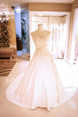 Şık bir gelin butiğinin mankeni üzerinde göz kamaştırıcı bir gelinlik Lüks Butik Showroom 'da Uzun Tren, Lace ve Fildişi Beyaz ile gösterimde Zarif Gelinlik
