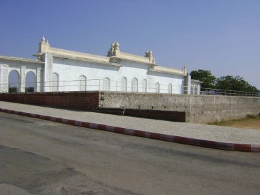 Güzel beyaz bina. Parkın içinde yol kenarında katranlı.