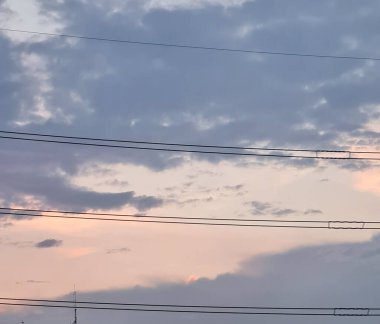 Şehirde akşam gökyüzünün soyut bulanıklığı, elektrik hatları, yumuşak bulanık stil, doğal bir arka plan olarak kullanım, odaklanmış bir tarz..