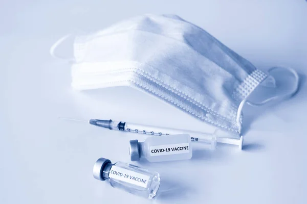 Covid-19 Önleme Konsepti: Covid-19 aşısı şişesi, iğne ve maskeli 1 ml plastik şırınga