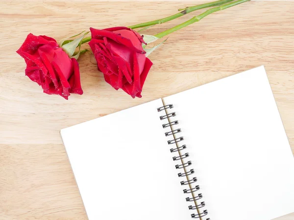 Zwei rote Rosenblüten und leeres Notizbuch 1 — Stockfoto