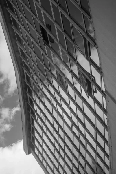 Arquitectura urbana abstracta, reflejo del cielo nublado en las ventanas del rascacielos del edificio cubierto de vidrio - Blanco y negro, Monocromo, Resumen — Foto de Stock