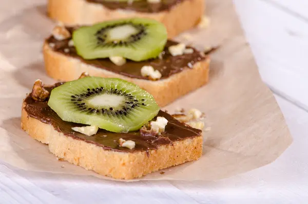 Toast with chocolate, kiwi fruit and nuts — Stock Photo, Image