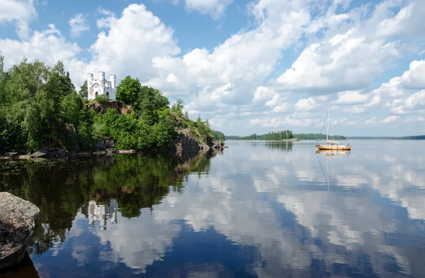 Landskap med kapell över sjön Stockbild