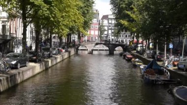 Arka planda bir şehir olan bir su kütlesi içinde küçük bir tekne.