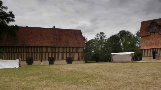 Un grand bâtiment en brique avec de l'herbe devant une maison — Video