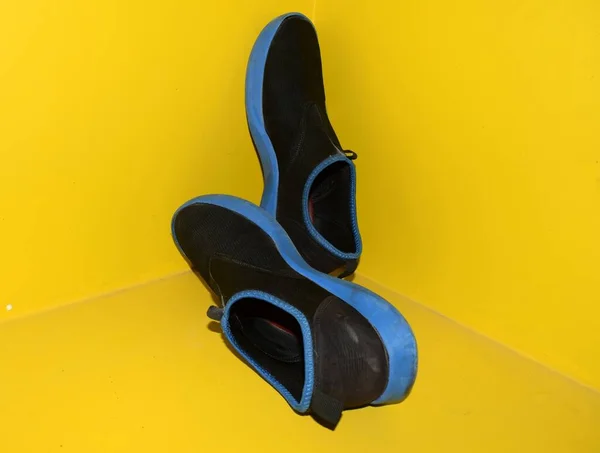 黄色背景的黑色运动鞋 — 图库照片