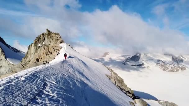 Człowiek jeżdżący na szczycie góry pokrytej śniegiem — Wideo stockowe
