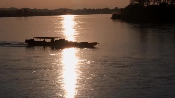 Un barco flotando a lo largo de un río junto a un cuerpo de agua — Vídeo de stock