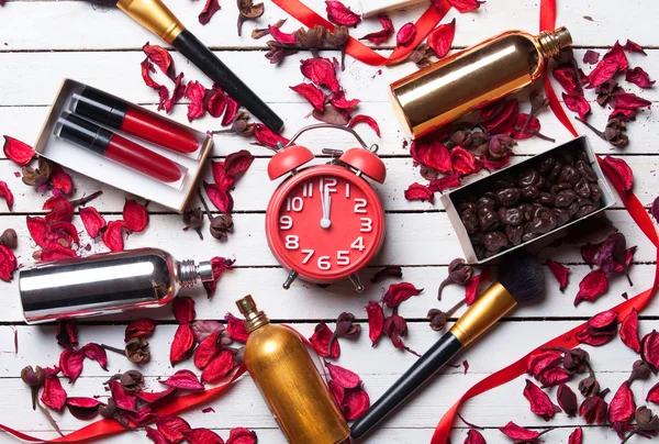 Relógio despertador e cosméticos de maquiagem — Fotografia de Stock