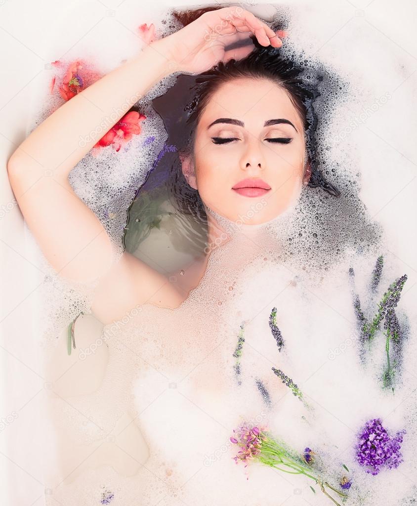 woman with flowers in the foam bath 