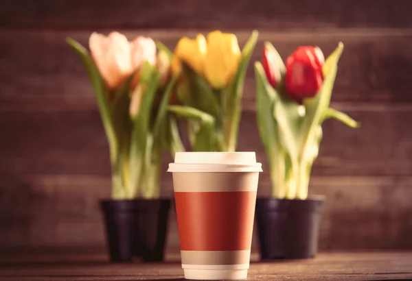 Racimos de tulipanes y taza sobre la mesa — Foto de Stock