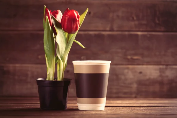 Ramo de tulipanes y copa sobre la mesa — Foto de Stock