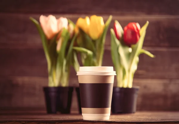 Racimos de tulipanes y taza sobre la mesa — Foto de Stock