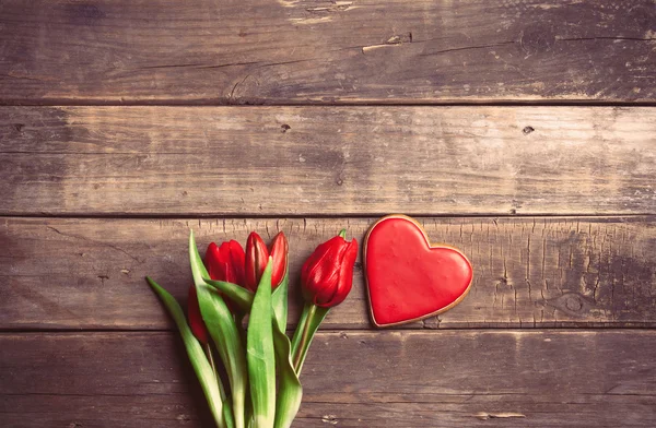 Stelletje tulpen en cookie op tafel — Stockfoto