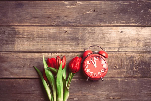 Куча тюльпанов и часов — стоковое фото