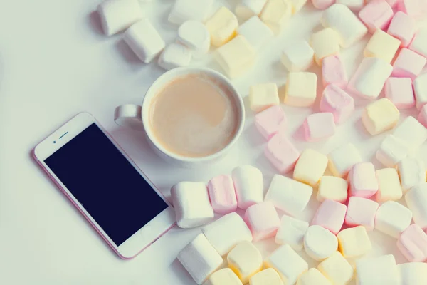 Marshmallow, mobiele telefoon en kopje koffie — Stockfoto