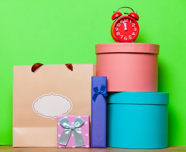 Paquetes y reloj en la mesa — Foto de Stock