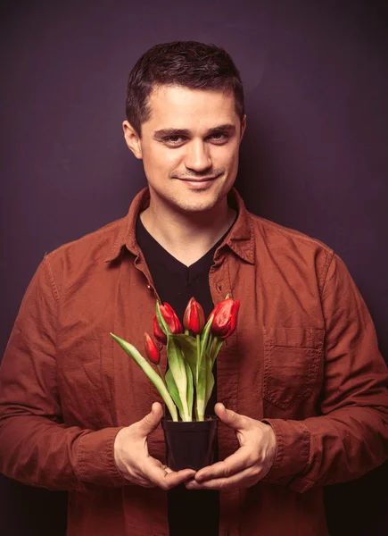 Ritratto di giovane uomo con tulipani — Foto Stock
