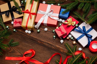 Noel hediyeleri ve ahşap masasında takılar olan çam dalları 