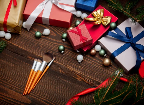 Makeup brushes near Christmas gifts on a table