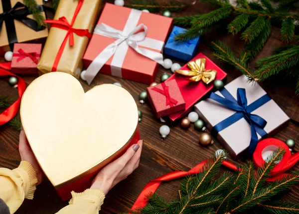 Vrouw Handen Houden Hart Vorm Doos Buurt Van Kerstgeschenken — Stockfoto