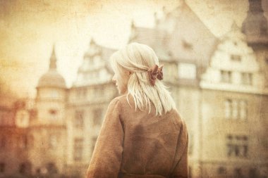 Sarışın, paltolu ve arkası eski kaleli. Resim eski renk biçiminde 