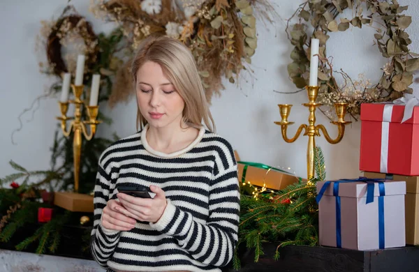 Vacker Kvinna Med Mobiltelefon Nära Jul Dekorerad Eldstad Hemma — Stockfoto