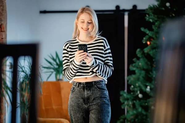 Schöne Frau Mit Handy Weihnachtlich Geschmückter Wohnung — Stockfoto
