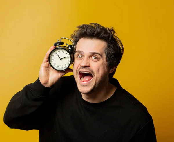 Sonriente Chico Blanco Con Despertador Sobre Fondo Amarillo — Foto de Stock