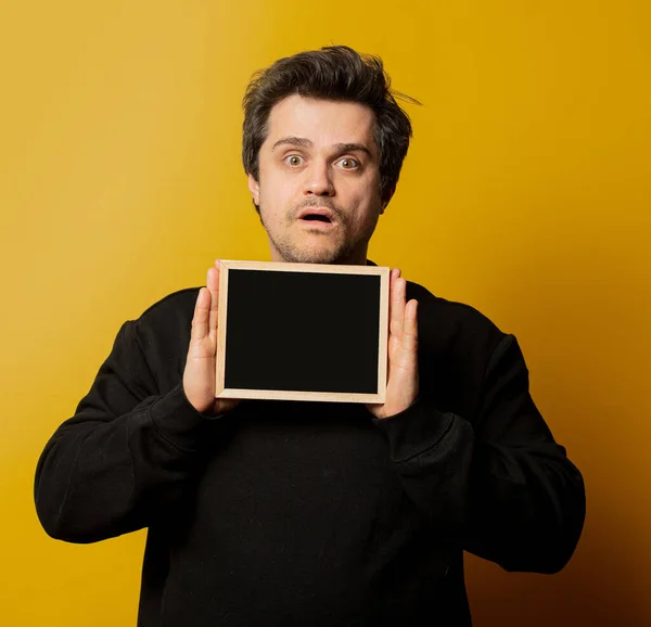 Chico Camisa Negra Con Pizarra Sobre Fondo Amarillo — Foto de Stock