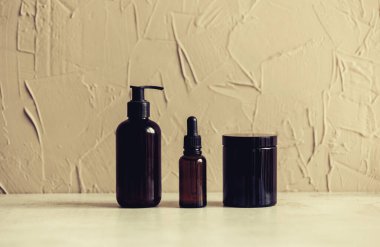 İki siyah şişe ve sarı arka planda bir kavanoz. 