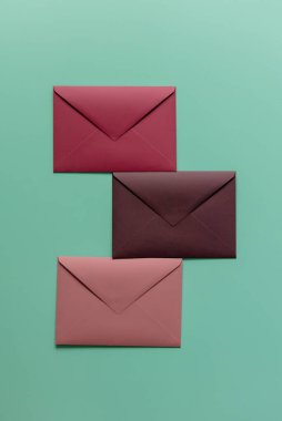 Yeşil arka planda üç kırmızı zarf. Üst görünüm 