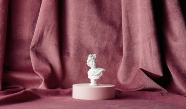 Little male bust on burgundy fabric background 