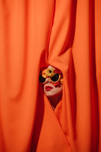 Frau Mit Sonnenbrille Und Blumen Versteckt Sich Orangefarbenen Vorhängen — Stockfoto