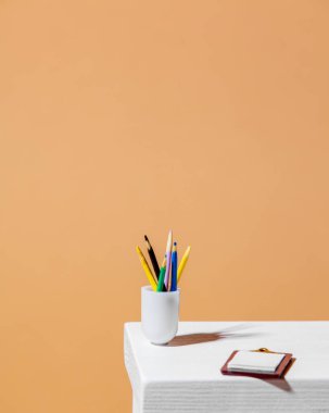 Masada kağıt ve kalemler var.